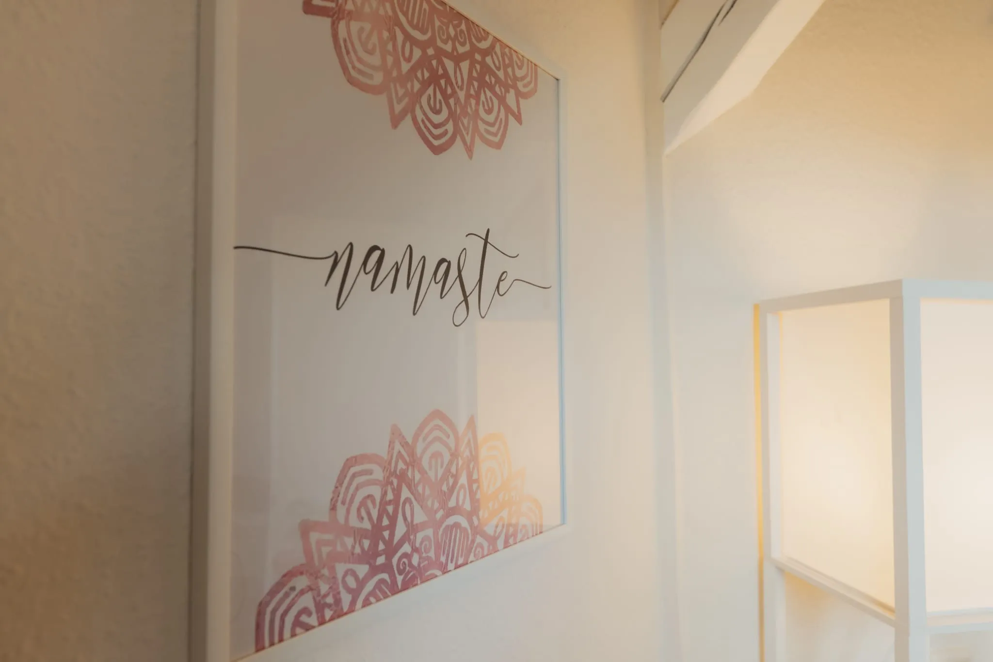 Bild mit dem Schriftzug „namaste“ zwischen rosa Mandalas